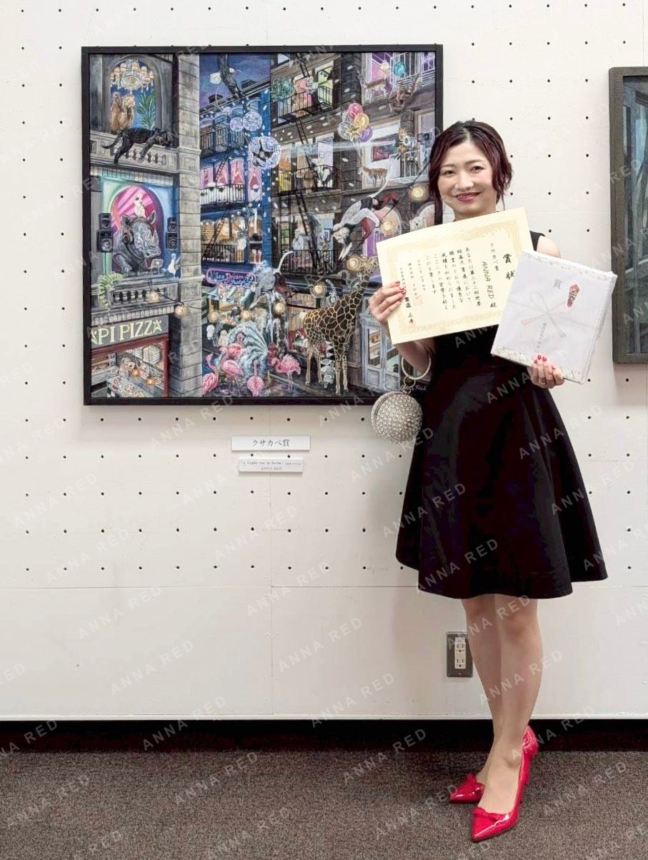 クサカベ賞の賞状を持つANNA REDと受賞作品